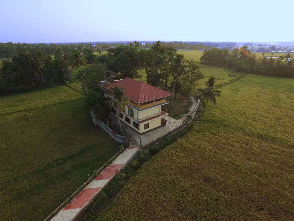 Aerial view of Athreya Ayurvedic Centre campus among paddy fields and palm trees